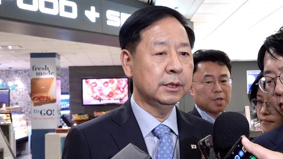 Deputy Prime Minister and Finance Minister Koo Yun-cheol talks to reporters upon arriving at Dulles International Airport on July 29. [JOINT PRESS CORPS]