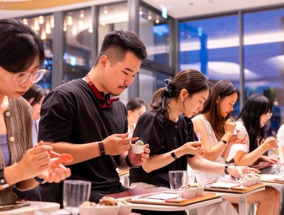 Members of a group judges selected from Baskin Robbins customers taste candidate flavors for the "Graymat Flavor Contest" at the Workshop by Baskin Robbins flagship store in Gangnam District, southern Seoul, on July 30. [BASKIN ROBBINS]
