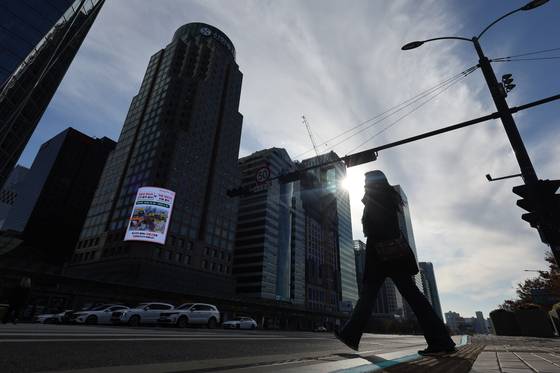 A pedestrian walks by the business district of Yeouido, western Seoul, on Nov. 17, 2024. [YONHAP]