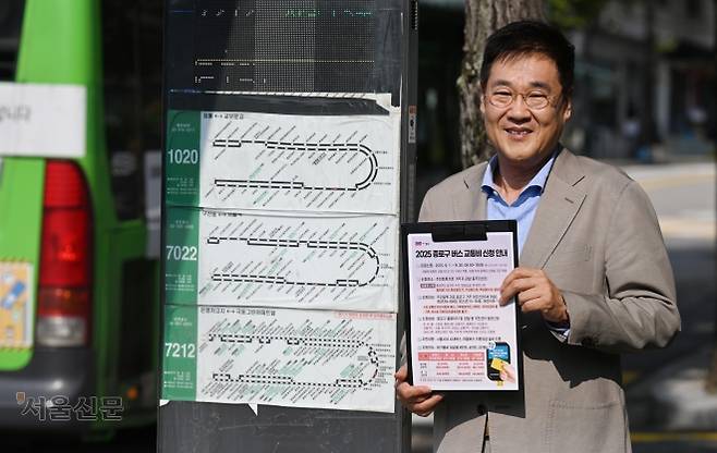 정문헌 서울 종로구청장이 지난 28일 종로구 부암동주민센터 인근 버스정류장에서 오는 9월부터 신청할 수 있는 버스 교통비 지원 안내문을 들어 보이고 있다. 안주영 전문기자