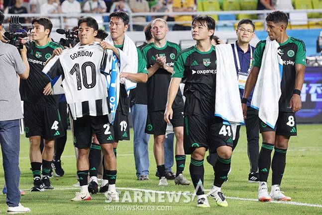 2025 쿠팡플레이 시리즈 팀 K리그 대 뉴캐슬 유나이티드 FC 경기가 수원 월드컵경기장에서 열렸다.  팀 K리그 선수들이 뉴캐슬에 1-0 승리를 한 후 응원단에 인사하고 있다. .앤서니 고든과 유니폼을 바꾼 어정원이 뉴캐슬 유니폼을 들어보이고 있다. /사진=김진경 대기자.