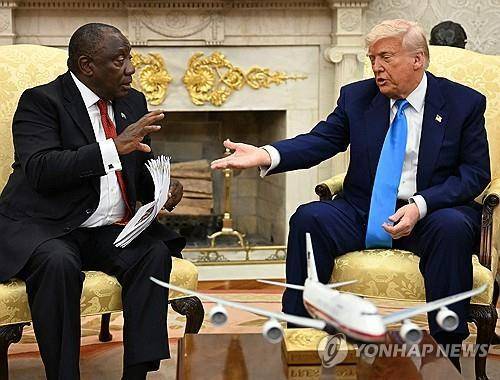 5월 21일(현지시간) 트럼프 대통령이 건넨 기사 뭉치 받아 든 라마포사 대통령 [AFP 연합뉴스 자료사진. 재판매 및 DB 금지]