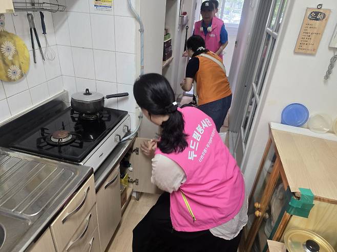 산본주몽1두드림봉사단과 이웃주민들이 함께 바퀴벌레 서식지인 싱크대, 화장실, 신발장 등에 집중 소독을 실시하고 있다. 사진=주택관리공단
