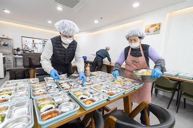 전북 익산시가 추진하는 ‘방학 초등 돌봄 도시락 공급 사업’ 종사자들이 아이들에게 전달할 도시락을 만들고 있다. 익산시 제공