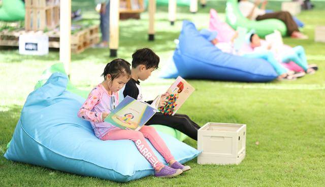 폭염이 이어진 29일 대구 수성구 수성패밀리파크에서 열린 '제9회 수성인문학제 수북수북 야외도서관' 행사에서 어린이들이 물놀이장 휴식 시간에 책을 보며 더위를 식히고 있다. 대구=연합뉴스