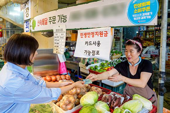 장뜰시장 한 고객이 민생안정지원금을 사용하고 있다. [사진=증평군]