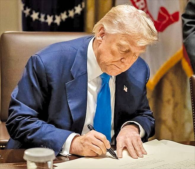 트럼프 “합의 기쁘다” … 李 “큰 고비 넘겨” 이재명 대통령이 한·미 관세협상이 타결된 31일 SNS에 “큰 고비를 하나 넘었다”고 밝혔다. 이 대통령이 대통령실에서 수석보좌관 회의를 주재하고 있다(오른쪽). 백악관은 30일(현지시간) 도널드 트럼프 미국 대통령이 문서에 서명하는 사진과 함께 “협상이 타결돼 기쁘다”는 글을 올렸다(왼쪽). 이 문서가 관세협상과 관련한 것인지는 밝히지 않았다.  김범준 기자·백악관 SNS 캡처