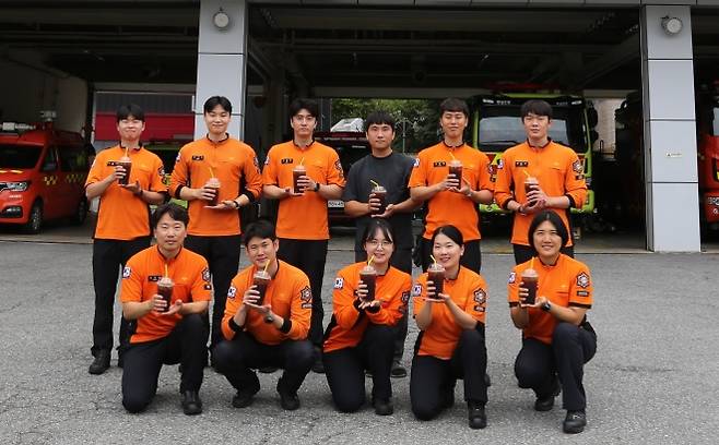 충남 천안서북소방서 직원들이 기부받은 커피를 들고 기부자에게 감사의 인사를 전달하고 있다. 천안서북소방서 제공