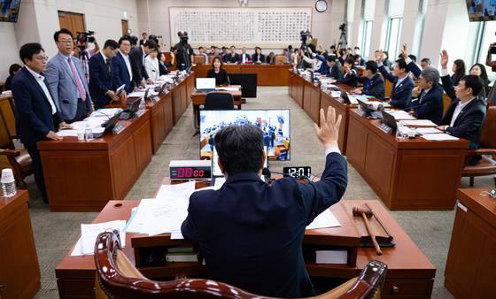이춘석 법제사법위원장이 1일 여의도 국회 법사위 전체회의에서 민주당 주도 거수 표결로 ‘노란봉투법’ 등을 통과시키자 국민의힘 의원(왼쪽)들이 일어서서 항의하고 있다. [뉴스1]