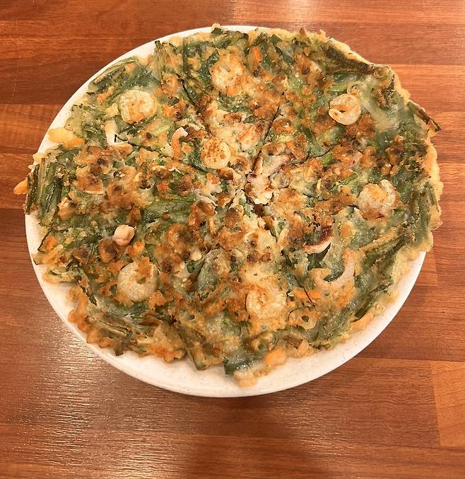 Haemul pajeon, or seafood green onion pancake, served at Halmeoni Mung Bean Pancake in Mapo-gu, western Seoul. (Park Jun-hee/The Korea Herald)
