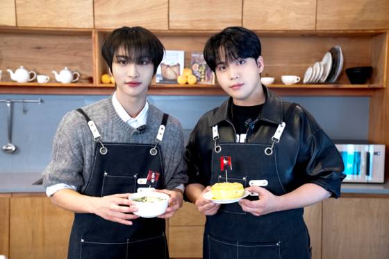Ateez members Seonghwa, left, and Jongho, right, pose for photos during an interview with the JoongAng Ilbo. [JOONGANG ILBO]