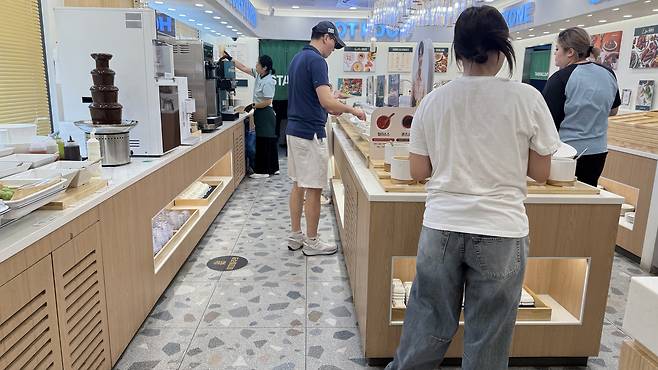 Diners help themselves at the salad bar at Shabu Allday in Songpa District, southern Seoul. [WOO JI-WON]