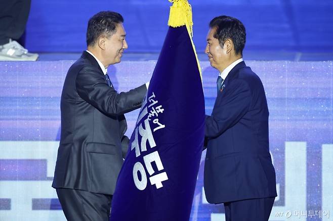 정청래 더불어민주당 신임 당대표가 2일 경기 고양시 킨텍스에서 열린 제2차 임시전국당원대회에서 김병기 원내대표로 부터 당기를 이양받고 있다./사진=뉴시스
