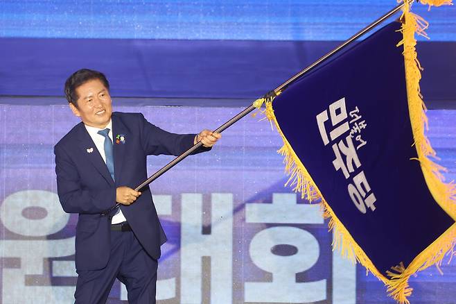 정청래 더불어민주당 신임 당대표가 2일 경기 고양시 킨텍스에서 열린 제2차 민주당 임사전국당원대회에서 김병기 당대표 직무대행 겸 원내대표로부터 받은 당기를 흔들고 있다. [연합]