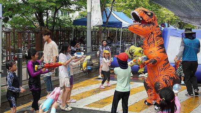 풍암동주민자치회가 주관한 ‘2025 풍암 워터페스타’가 지난 1-2일 이틀간 광주 서구 풍암동 일대에서 열렸다. 사진은 2일 아이들이 ‘쥬라기 공룡군단과 물총싸움’ 프로그램에 참여해 공룡 탈을 쓴 주민자치회 관계자에게 물총을 쏘는 모습./주성학 기자