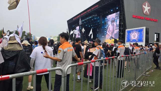 2025 인천 펜타포트 락 페스티벌 마지막 날인 3일 오후 인천 의용소방대원들이 비를 맞아가며 관객들이 펜스에 부딪히지 않도록 안내하고 있다. 장민재기자