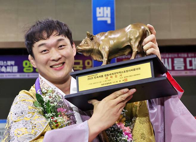 4일 충북 영동체육관에서 열린 위더스제약 2025 민속씨름 영동세계국악엑스포장사씨름대회서 태백장사(80kg이하)에 등극한 문준석(수원시청)이 황소트로피를 들고 기념 사진을 찍고 있다. 사진=대한씨름협회