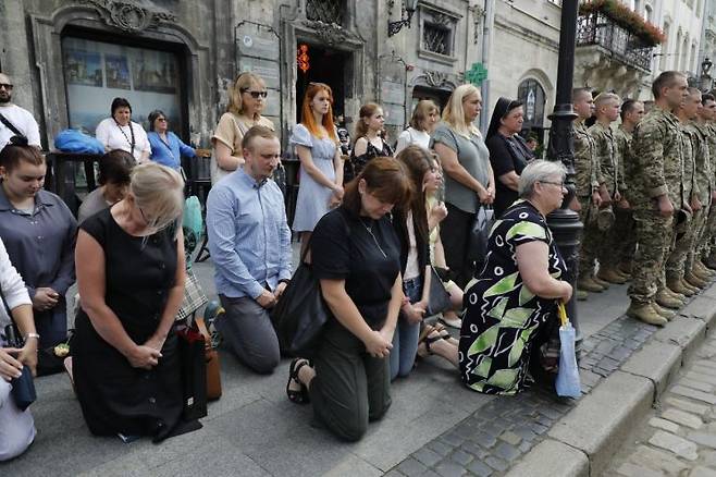 지난달 25일 금요일, 우크라이나 리비우 중심부에서 열린 장례식에서 러시아 포로로 사망한 우크라이나 군인 12명에게 경의를 표하는 모습. AP·연합뉴스