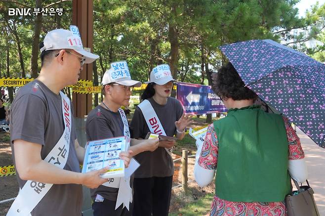 부산은행 직원들이 부산바다축제 현장에서 보이스피싱 예방 캠페인을 벌이고 있다. 부산은행 제공.