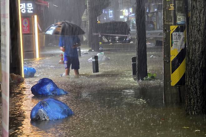 무안군을 중심으로 광주·전남 곳곳에 극한호우가 쏟아진 3일 오후 광주 북구 운암동 도심에서 한 시민이 침수된 거리를 이동하고 있다. 광주=연합뉴스