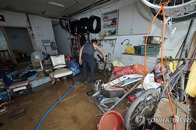 아수라장 된 가게 (광주=연합뉴스) 김혜인 기자 = 17일만에 극한호우가 다시 내린 4일 광주 북구 신안동 한 상점에서 시민이 흙탕물을 씻어내고 있다. 2025.8.4 in@yna.co.kr
