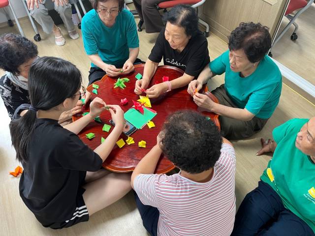 "이걸 이렇게 접으시면 돼요. 할머니" 최근 지역 경로당을 찾은 청송 현서중·고등학교 학생들이 어르신들에게 종이접기를 가르쳐주는 등 자기주도형 봉사활동을 펼쳤다. 청송교육지원청 제공