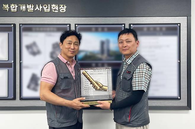 이승환 롯데건설 주택안전팀 상무(왼쪽)가 현장 소장에게 ‘안전 바통’을 전달하고 있다. /롯데건설 제공