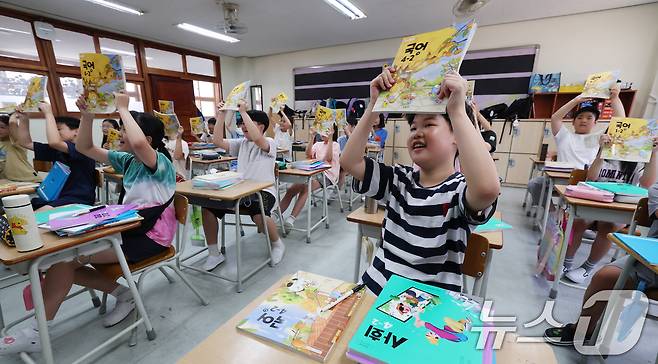 5일 오전 여름방학을 마치고 개학한 경기 수원시 영통구 잠원초등학교에서 학생들이 새학기 교과서를 들어보이고 있다. 2025.8.5/뉴스1 ⓒ News1 김영운 기자
