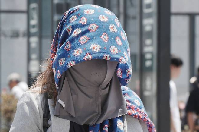 5일 일본 도쿄에서 열기를 식히기 위해 머리에 천을 두른 시민이 길을 걷고 있다. 도쿄/AFP 연합뉴스