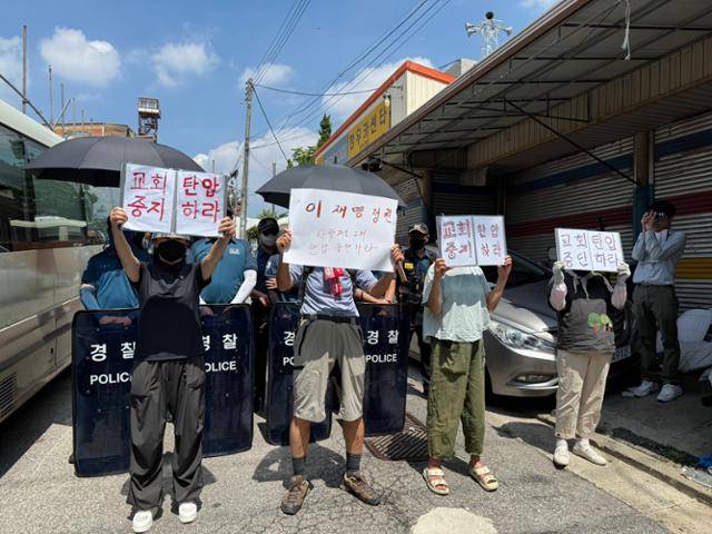 5일 서울 성북구 사랑제일교회 정문 쪽 도로에서 교회 신도들이 '교회 탄압 중지하라'고 쓰인 손팻말을 들고 있다. 문지수 기자