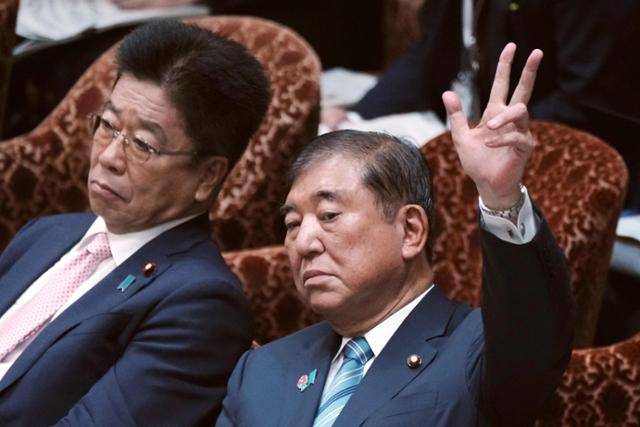 이시바 시게루(오른쪽) 일본 총리가 지난 4일 도쿄 중의원 예산위원회에 참석해 의원들의 질문에 답하려 손을 들고 있다. 도쿄=AFP 연합뉴스
