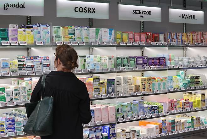 A shopper looks at beauty products stocked at a store in Seoul on Aug. 1. [YONHAP]