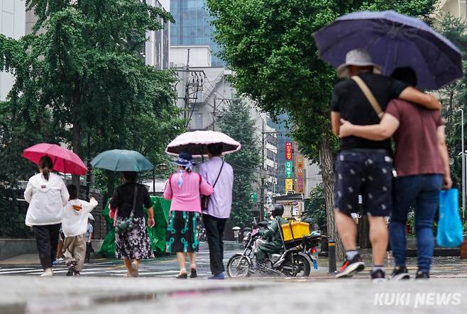 지난달 16일 서울 중구 청계천 인근에서 시민들이 우산을 받쳐들고 이동하고 있다. 유희태 기자