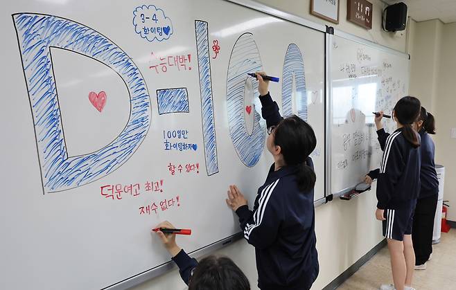 2026학년도 대학수학능력시험 D-100일을 하루 앞둔 4일 오전 부산 수영구 덕문여자고등학교 3학년 교실에서 수험생들이 칠판에 수능 응원 문구를 적고 있다. [연합]