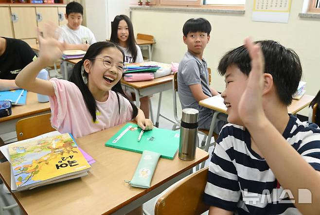 [수원=뉴시스] 김종택 기자 = 5일 여름방학을 마치고 개학한 경기 수원시 영통구 잠원초등학교 4학년2반 학생들이 오랜만에 만난 친구들과 반갑게 인사하고 있다. 2025.08.05. jtk@newsis.com