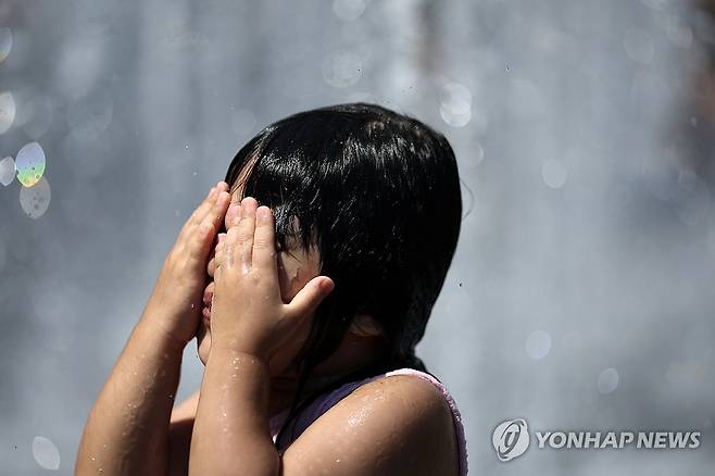 폭염이 이어진 지난달 27일 서울 광화문광장에서 한 어린이가 물놀이를 하고 있다. [연합뉴스 자료사진]