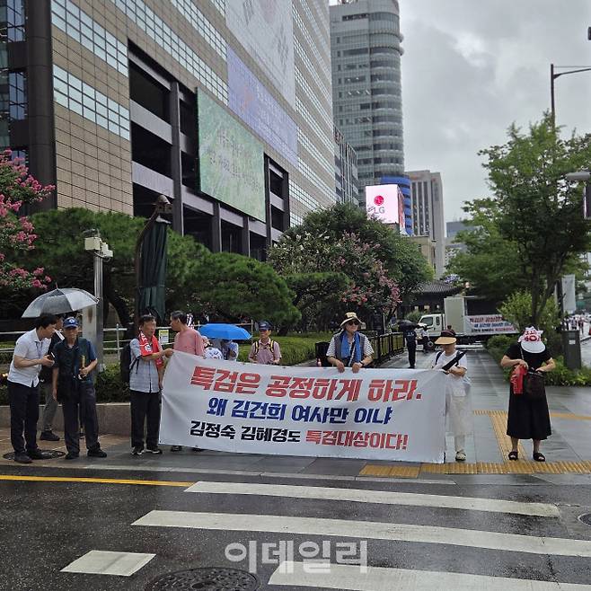6일 오전 김건희 특검 사무실이 위치한 서울 종로구 광화문 KT WEST 빌딩과 광화문역 사이 교보빌딩 앞에서 윤석열 전 대통령 부부 지지자들이 현수막을 펼치고 서있는 모습. (사진=김현재 수습기자)