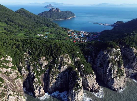 가파른 해변 절벽을 두르고, 완만한 산사면에 편안하게 앉은 손죽도 마을. 멀리 고흥 땅을 바라본다. 섬마을의 고단함과 따뜻함이 느껴진다.