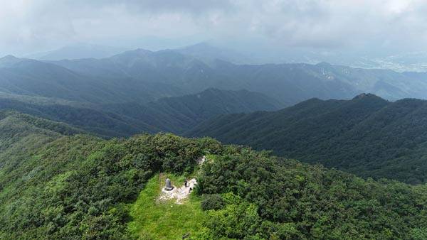 경남 함양 백운산 정상에서 드론을 날려 본 북쪽 백두대간 능선이다. 사진 왼쪽이 영취산이며 능선은 구시봉(깃대봉)을 거쳐 남덕유산으로 이어지지만, 답사 때 짙은 구름이 덮여 덕유 능선은 볼 수 없었다. 정면 덕운봉과 제산봉 사이에 부전계곡이 흘러내린다.
