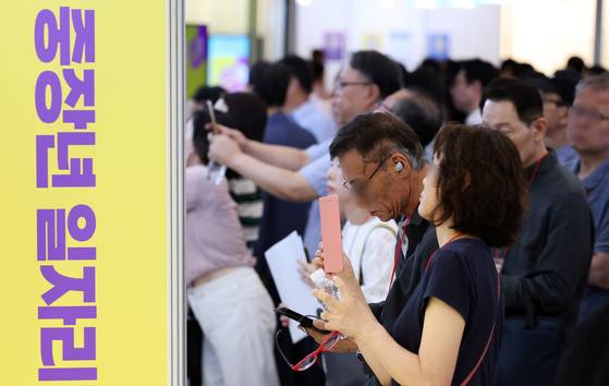 Job seekers look at a hiring bulletin board at the 2025 Seoul Job Fair for Middle-aged People at Dongdaemun Design Plaza in Jung District, central Seoul, on July 1. [NEWS1]
