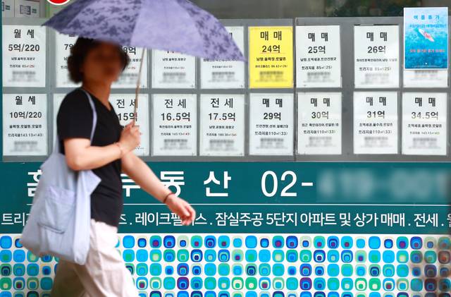 지난 7월 31일 서울 시내에서 한 시민이 창에 매물이 적혀 있는 부동산중개업소 앞을 지나고 있다. 연합뉴스
