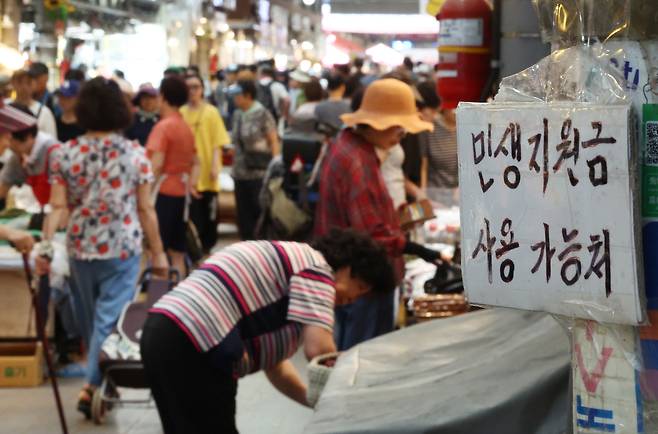 서울 동대문구 청량리종합시장에 민생회복 소비쿠폰 관련 안내문이 붙어 있다.  [연합]