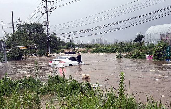 지난달 17일 곡교지하차도에 진입하다 급격히 불어난 물에 잠겸버린 승용차와 보닛에 올라가 구조를 기다리는 차주의 모습.
