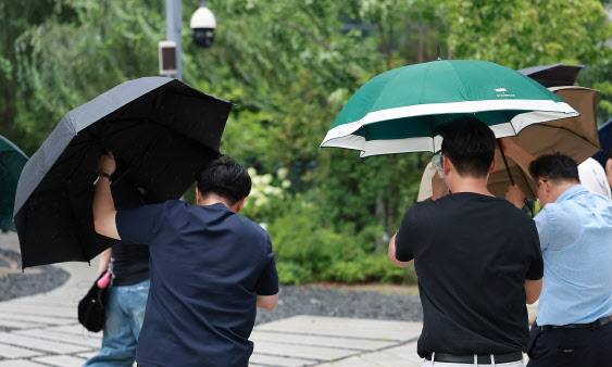 돌풍을 동반한 비가 내린 6일 오후 서울 종로구 광화문 인근 거리에서 시민들이 우산을 붙잡은채 걸어가고 있다.(사진=뉴시스)