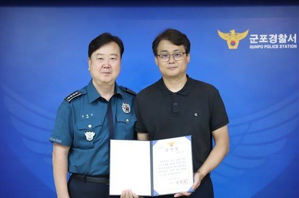 모텔 업주 A씨(오른쪽)가 보이스피싱 범죄 피해를 막은 공로를 인정받아 감사장을 수여받고 있다. 경기 군포경찰서