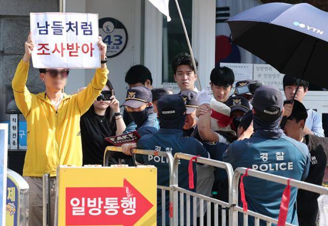 김건희 여사의 각종 의혹을 수사하는 민중기 특별검사팀이 윤석열 전 대통령에 대한 체포영장 집행에 나선 1일 오전 경기 의왕 서울구치소에서 윤 전 대통령 지지자가 남들처럼 조사받아 라는 피켓을 든 한 시민에게 달려가자 경찰이 저지하고 있다. 뉴스1