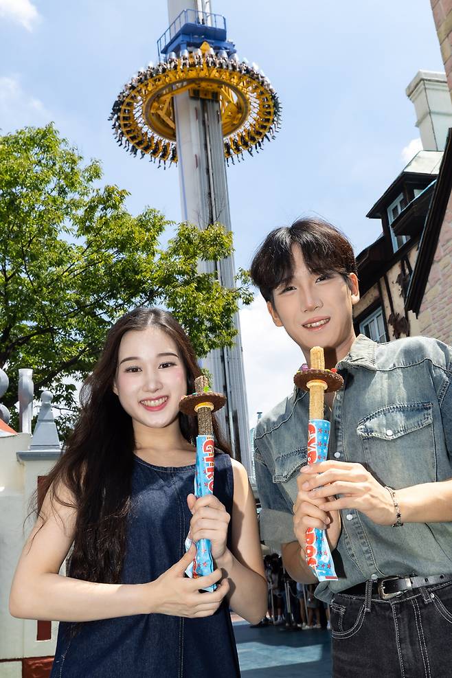 자이로추로스를 들고 자이로드롭 앞에서 사진찍는 사람들 / 사진=롯데월드 어드벤처