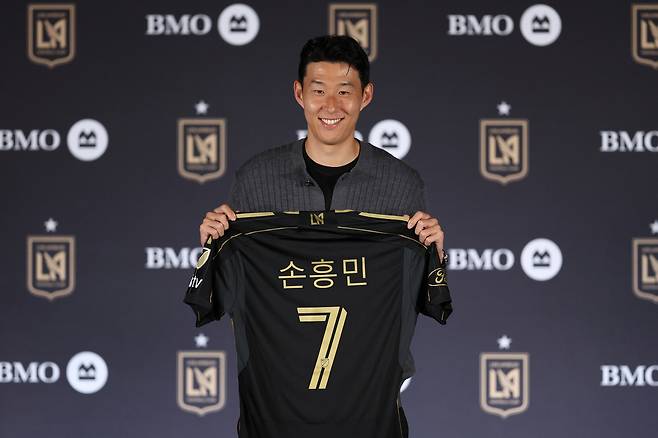 손흥민이 6일(현지시간) 미국 로스앤젤레스(LA) BMO 스타디움에서 열린 로스앤젤레스FC(LAFC) 입단 기자회견에서 유니폼을 들고 기념촬영을 하고 있다. [연합]