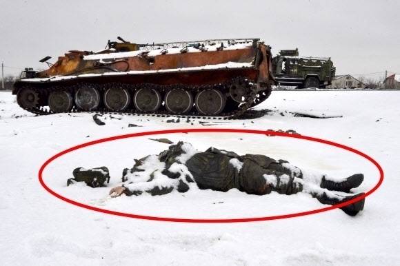 우크라이나 동북부 하르키우 외곽 도로에 26일(현지시간) 파괴된 러시아군 차량들이 멈춰서 있는 가운데 한 러시아 병사의 시신이 널부러져 있다. 2022.2.27 AFP 연합뉴스