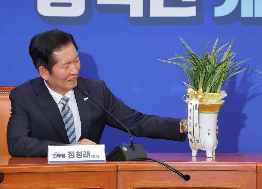 더불어민주당 정청래 신임 대표가 4일 국회 당대표실에서 우상호 대통령실 정무수석으로부터 받은 이재명 대통령의 취임 축하 난을 보고 있다. 연합뉴스